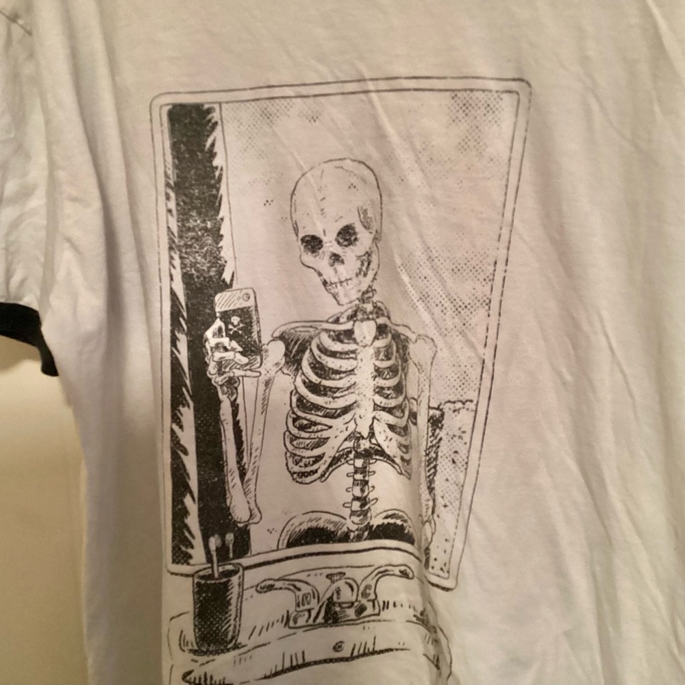 SKELETON TAKING A SELFIE IN A MIRROR.